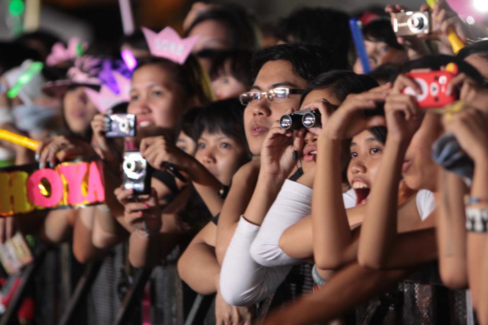 Filipino K-Pop fans eagerly watch their favorite K-Pop group idols during the "Dream Kpop Fantasy Concert" held at the Mall of Asia grounds in Pasay city, south of Manila on 19 January 2013.