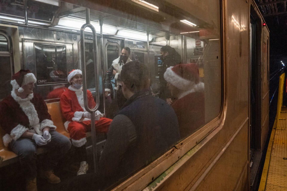 People dressed in Santa Claus costumes ride the subway while participating in SantaCon in New York City. (Photo by David Dee Delgado/Getty Images)