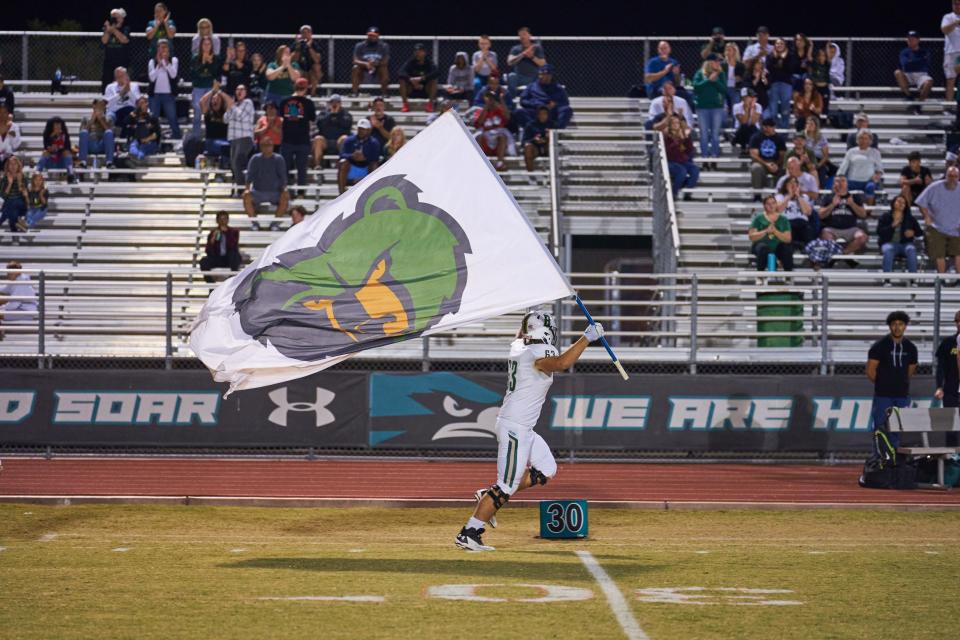 Basha junior defensive lineman James Durand takes the field while flying the Basha flag at the Highland High School football field in Gilbert, Ariz. on Friday, Oct. 22, 2021.