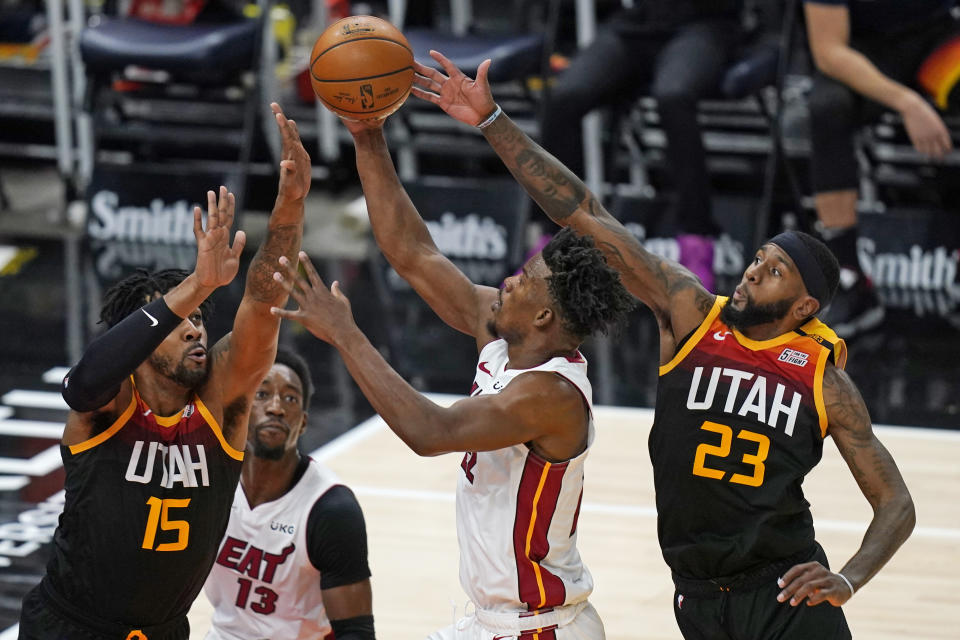 Utah Jazz's Derrick Favors (15) and Royce O'Neale (23) defend against Miami Heat forward Jimmy Butler, center, in the second half during an NBA basketball game Saturday, Feb. 13, 2021, in Salt Lake City. (AP Photo/Rick Bowmer)