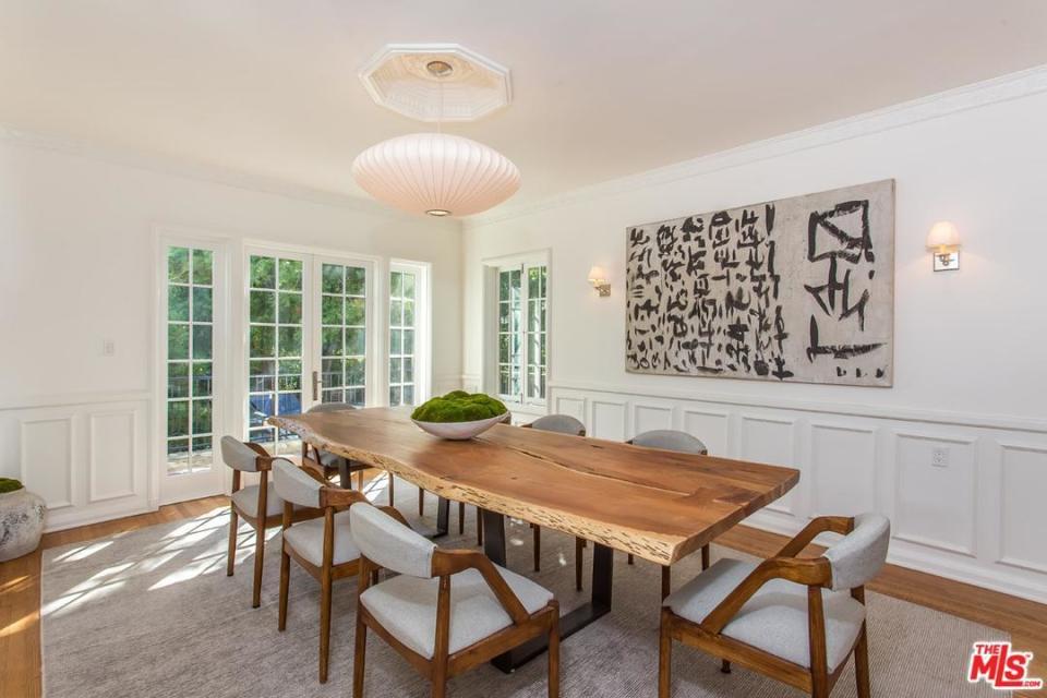 <p>The main dining table is made from a solid piece of wood, with a Japanese theme print on th wall. (Redfin/MLS) </p>