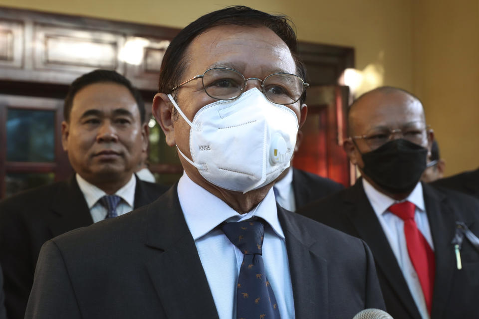 FILE - Cambodia National Rescue Party's President Kem Sokha, center, speaks to journalists before heading to the court in his house in Phnom Penh, Cambodia, on Jan. 19, 2022. Kem Sokha, Cambodia's most prominent opposition politician not in exile, is scheduled Friday, March 3, 2023, to hear the verdict in his trial for treason, for which he was arrested in 2017 as part of a government crackdown on the opposition. (AP Photo/Heng Sinith, File)