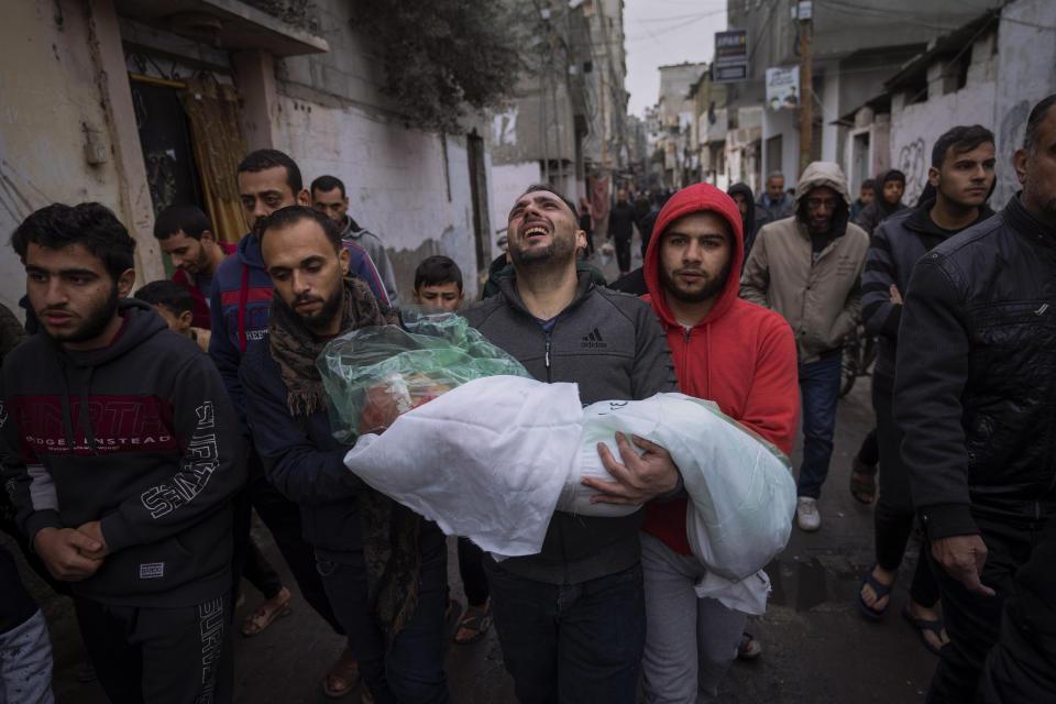 Mohammad Shouman carries the body of his daughter, Masa, who was killed in an Israeli bombardment of the Gaza Strip, during her funeral in Rafah, southern Gaza, Wednesday, Jan. 17, 2024. (AP Photo/Fatima Shbair)