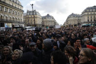 A crowd listens to musicians performing outside the Palais Garnier opera house, Saturday, Jan. 18, 2020 in Paris. As some strikers return to work, with notable improvements for train services that have been severely disrupted for weeks, more radical protesters are trying to keep the movement going. (AP Photo/Kamil Zihnioglu)