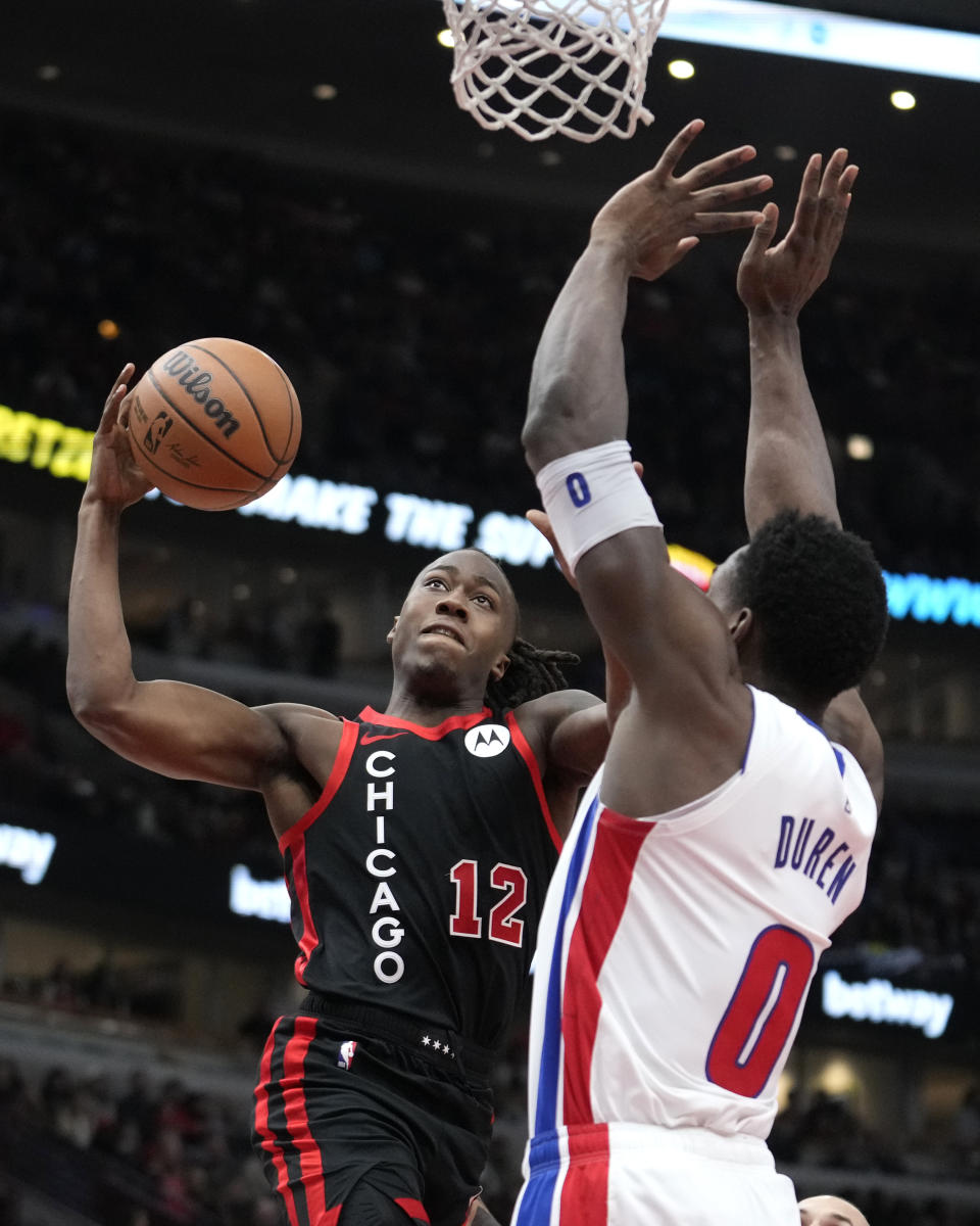 Chicago Bulls' Ayo Dosunmu (12) drives to the basket as Detroit Pistons' Jalen Duren defends during the first half of an NBA basketball game Tuesday, Feb. 27, 2024, in Chicago. (AP Photo/Charles Rex Arbogast)