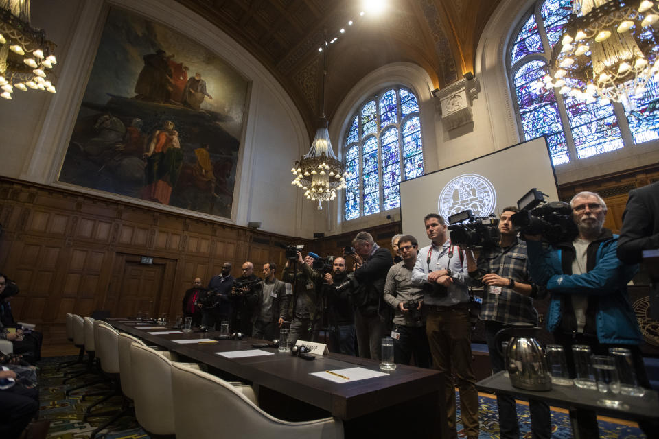 Journalists wait for Myanmar's leader Aung San Suu Kyi to enter the court room of the International Court of Justice for the first day of three days of hearings in The Hague, Netherlands, Tuesday, Dec. 10, 2019. Aung San Suu Kyi will represent Myanmar in a case filed by Gambia at the ICJ, the United Nations' highest court, accusing Myanmar of genocide in its campaign against the Rohingya Muslim minority. (AP Photo/Peter Dejong)