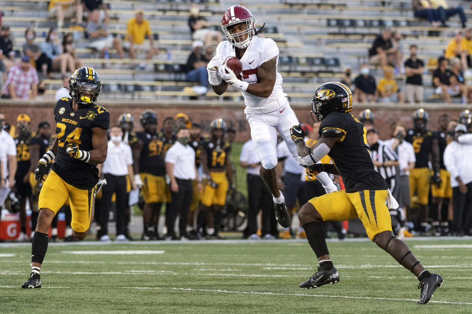 FILE - In this Saturday, Sept. 26, 2020, file photo, Alabama wide receiver Jaylen Waddle, center, pulls down a reception between Missouri's Tyree Gillespie, right, and Ishmael Burdine, left, during the first quarter of an NCAA college football game in Columbia, Mo.  No. 2 Alabama doesn’t look like a team that lost quarterback Tua Tagovailoa and two first-round receivers. Quarterback Mac Jones still has a selection of some of the SEC’s best playmakers, including Jaylen Waddle. (AP Photo/L.G. Patterson, File)