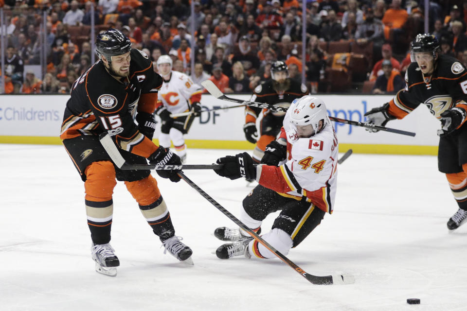 Anaheim Ducks' Ryan Getzlaf, left, shoots under the defense by Calgary Flames' Matt Bartkowski during the second period in Game 1 of a first-round NHL hockey Stanley Cup playoff series Thursday, April 13, 2017, in Anaheim, Calif. (AP Photo/Jae C. Hong)