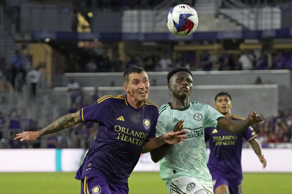 Orlando City defender Kyle Smith, left, battles Atlanta United midfielder Derrick Etienne for position on the ball during the first half of an MLS soccer match, Saturday, May 27, 2023, in Orlando, Fla. (AP Photo/John Raoux)
