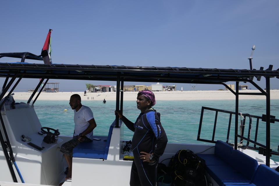 A diver looks out from the boat near the Island of Um Khorah, the center of Abu Dhabi's Coral Reef Rehabilitation project, on a trip to restore corals in Abu Dhabi, United Arab Emirates, Thursday, May 25, 2023. Restoration efforts are underway in the United Arab Emirates as coral reefs face threats in the Persian Gulf and the Gulf of Oman. (AP Photo/Kamran Jebreili)