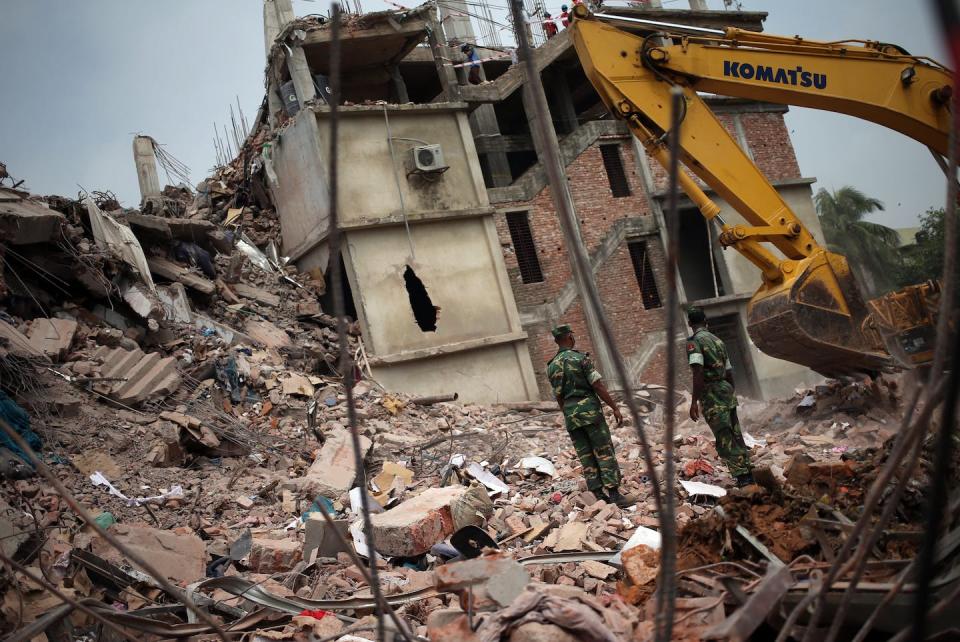 Army personnel watch as workers toil in the collapsed garment factory building in April 2013 in Savar, near Dhaka, Bangladesh. (AP Photo/Wong Maye-E)