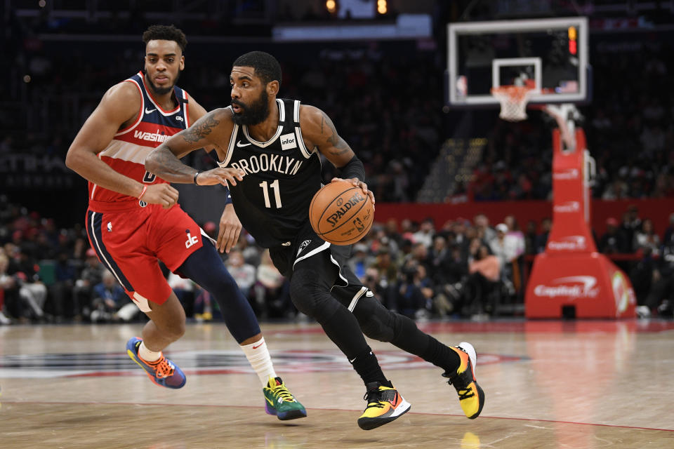 Brooklyn Nets guard Kyrie Irving (11) dribbles the ball against Washington Wizards forward Troy Brown Jr. (6) during the second half of an NBA basketball game, Saturday, Feb. 1, 2020, in Washington. The Wizards won 113-107. (AP Photo/Nick Wass)