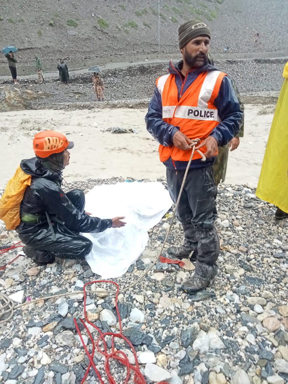 Indian Department of Disaster Management soldiers cover a body of a pilgrim killed in a cloudburst near the base camp of the holy cave shrine of Amarnath in south of Kashmir Himalayas, in India, Friday, July 8, 2022. A cloudburst hit near the base camp of the holy cave shrine of Amarnath in south Kashmir Himalayas on Friday, many have lost their lives and more than 40 are feared missing, according to the officials. (Jammu and Kashmir Government's Department of Disaster Management via AP)