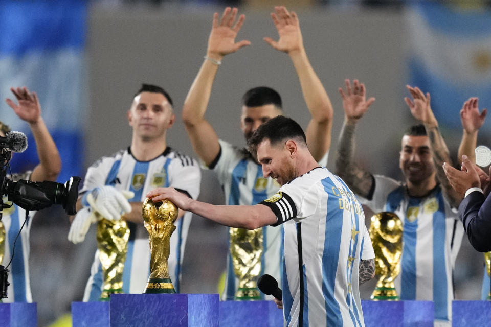 Argentina's Lionel Messi touches the FIFA World Cup trophy during a celebration for fans after an international friendly soccer match against Panama in Buenos Aires, Argentina, Thursday, March 23, 2023. (AP Photo/Natacha Pisarenko)