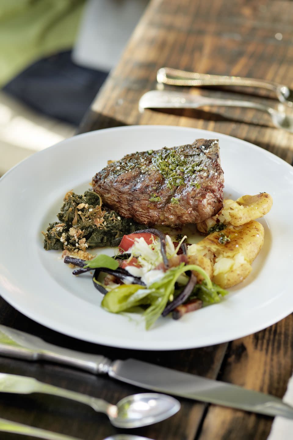 grilled bonein bison steaks with crisped potatoes on a plate