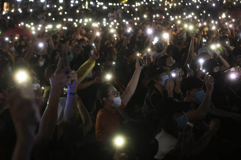 Pro-democracy activities display mobile phones with flash lights on during a protest at Democracy Monument in Bangkok, Thailand, Sunday, Aug, 16, 2020. Protesters have stepped up pressure on the government demanding to dissolve the parliament, hold new elections, amend the constitution and end intimidation of the government's opponents. (AP Photo/Sakchai Lalit)