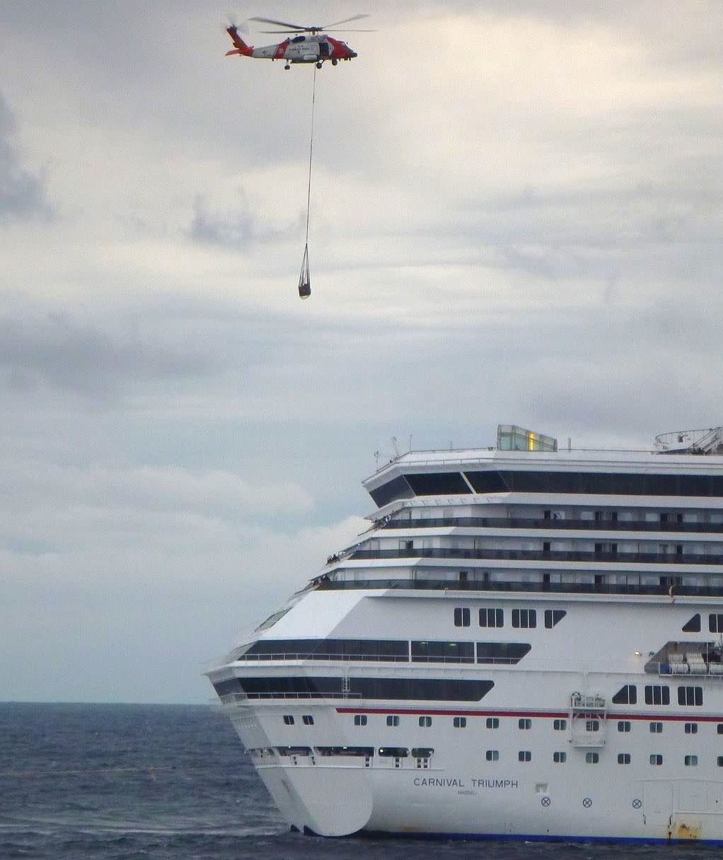 A Coast Guard helicopter delivers approximately 3,000 lb (1,400 kg) of equipment, which included a generator and electrical cables, to Carnival Triumph in the Gulf of Mexico, February 13, 2013.