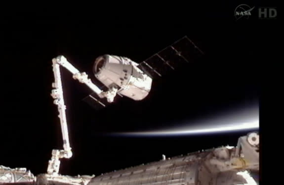 Dragon capsule attached to the Canadarm2 floats with the Earth's limb in the background, May 25, 2012.