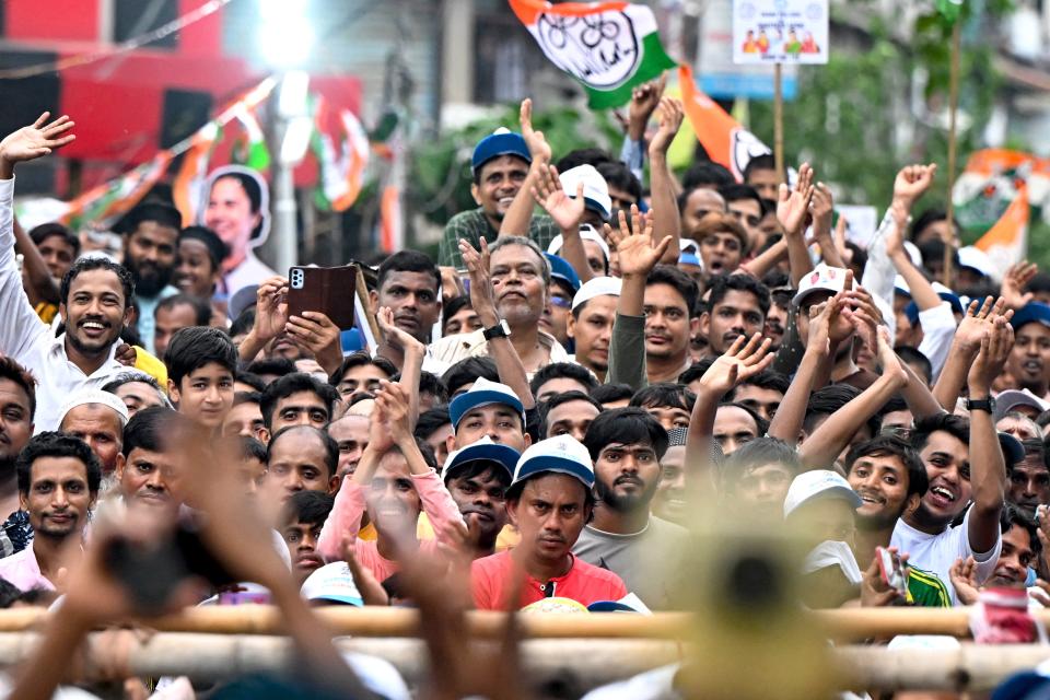 Supporters of Trinamool Congress (TMC) party cheer during an election campaign (AFP via Getty Images)