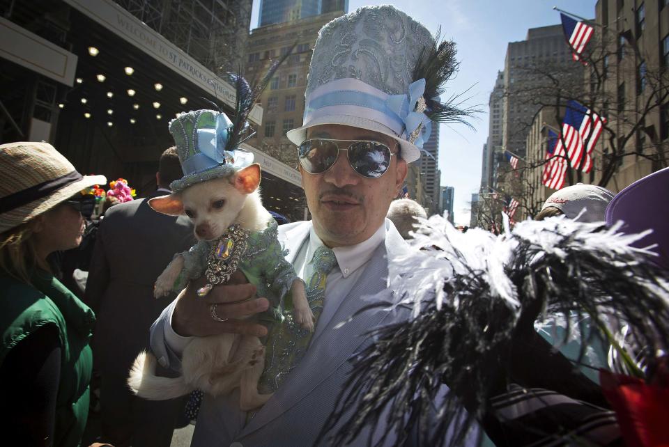 A man holds his dog as they participate in the annual Easter Bonnet Parade in New York