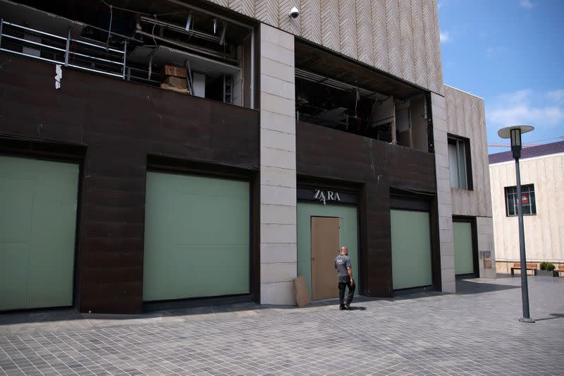 People walk past closed shops some of which were damaged from a massive explosion at Beirut port