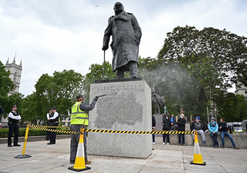 The statue of former British prime minister Winston Churchill is cleaned in Parliament Square, central London on June 8, 2020, after being defaced, with the words (Churchill) "was a racist" written on it's base by protesters at a demonstration on June 7, 2020, organised to show solidarity with the Black Lives Matter movement. - Most marches at the weekend were peaceful but there were flashes of violence, including in London, where the statue of World War II leader Winston Churchill in Parliament Square was defaced. (Photo by JUSTIN TALLIS / AFP) (Photo by JUSTIN TALLIS/AFP via Getty Images)