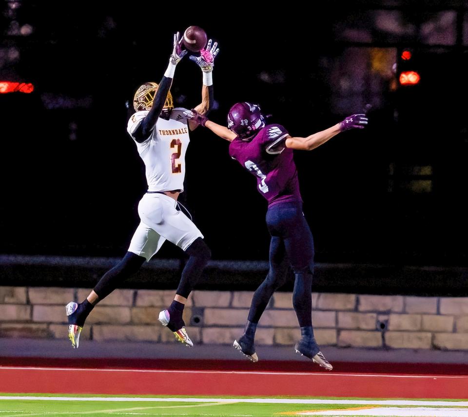 Thorndale wide receiver Clason Beasley reaches to snare a pass as Johnson City defensive back Johnny Slawinski defends.