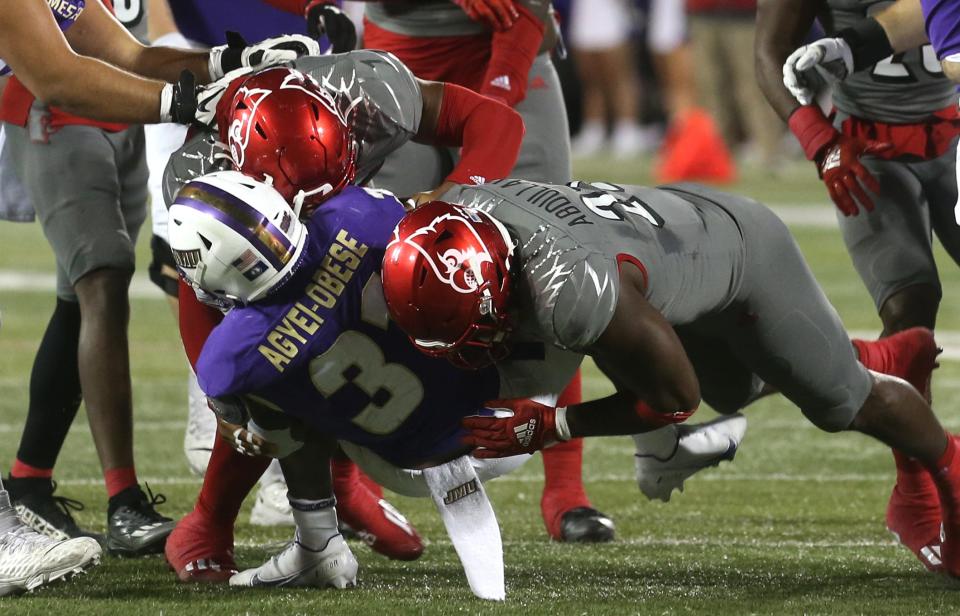 Louisville’s Yasir Abdullah and Dorian Jones sacked James Madison’s Percy Agyei-Obesse.Nov. 5, 2022