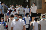 Students wearing face masks to protect against the new coronavirus leave school after finishing the first day of China's national college entrance examinations, known as the gaokao, in Beijing, Tuesday, July 7, 2020. China's college entrance exams began in Beijing on Tuesday after being delayed by a month due to the coronavirus outbreak. (AP Photo/Andy Wong)