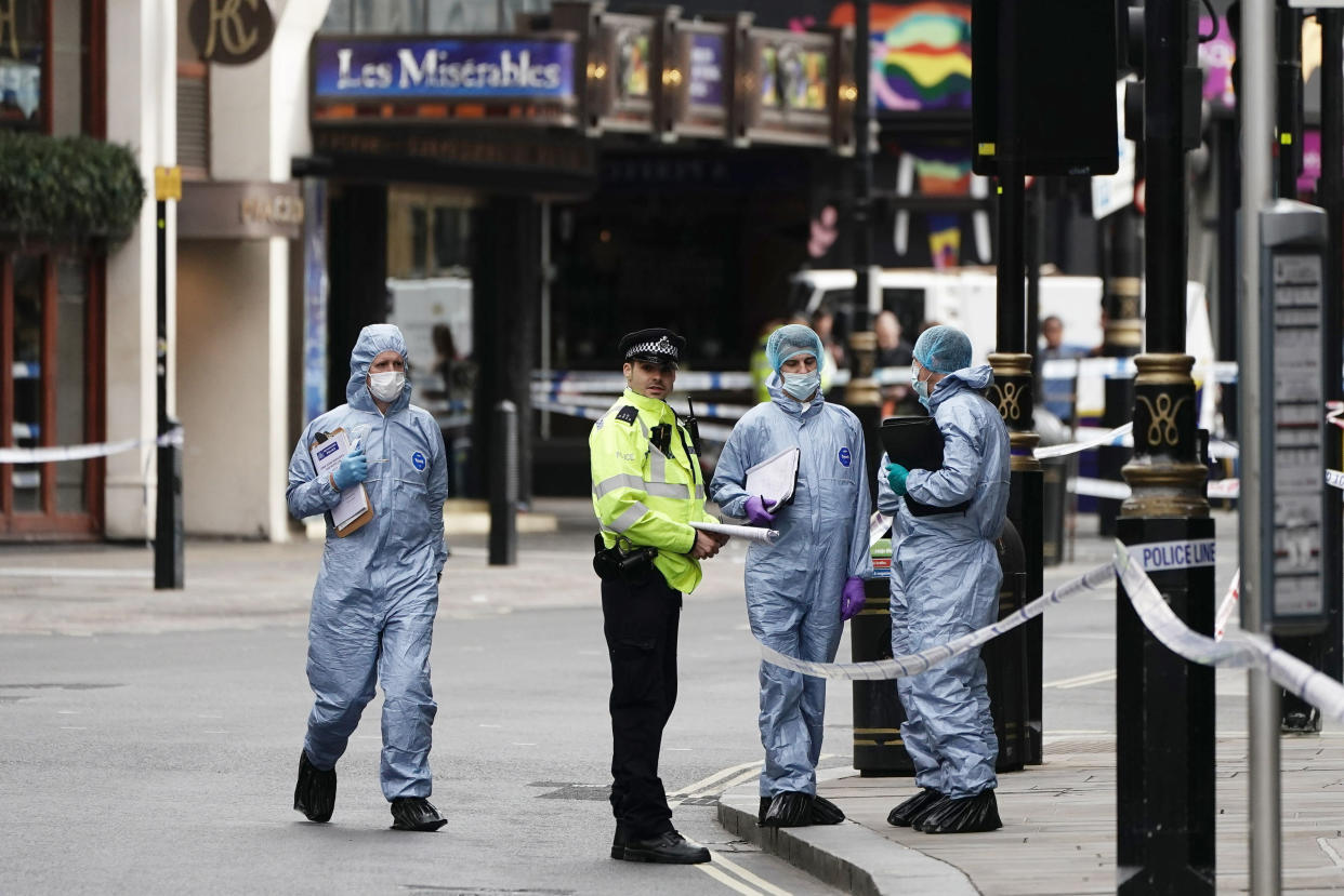 Forensics officers and police at the scene in Shaftesbury Avenue, where two male police officers were stabbed, in London, Friday, Sept. 16, 2022. London’s police force says two officers have been hospitalized after being stabbed in central London early Friday. It says the attack is not being treated as terrorism. The Metropolitan Police force says officers “encountered a man with a knife” in the Leicester Square area, a busy tourist hub, at around 6 a.m. (Aaron Chow/PA via AP)