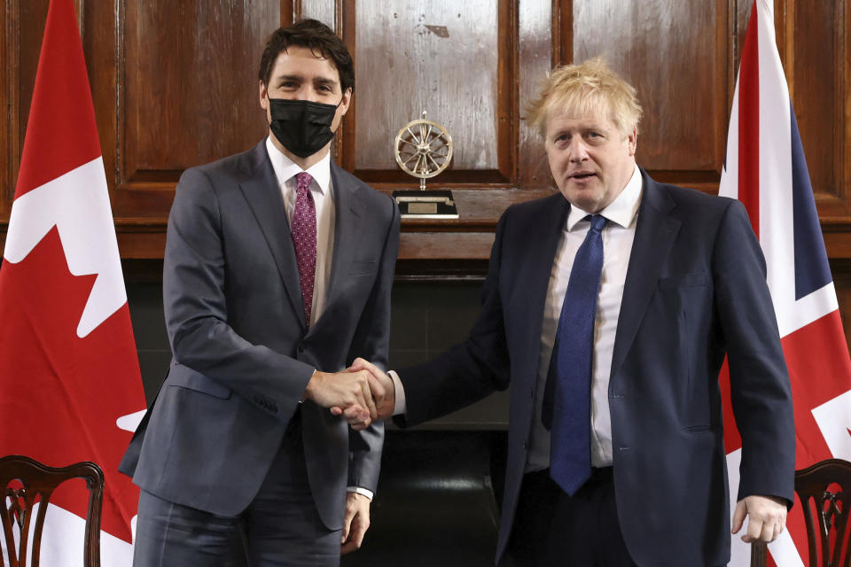 British Prime Minister Boris Johnson, right, shakes hands with Canadian Prime Minister Justin Trudeau during a visit to RAF Northolt in London, Monday, March 7, 2022. (Henry Nicholls, Pool via AP)