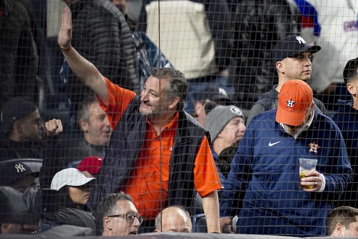 Senator Ted Cruz, R-Texas, left, waves to spectators while attending Game 4 of an American League Championship baseball series between the New York Yankees and the Houston Astros, Sunday, Oct. 23, 2022, in New York. 