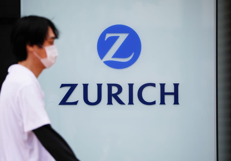 A man wearing a protective face mask walks past in front of a office building of the Japanese unit of Zurich Insurance Group during a nationwide state of emergency in Tokyo, as the spread of the coronavirus disease (COVID-19) continues in Japan