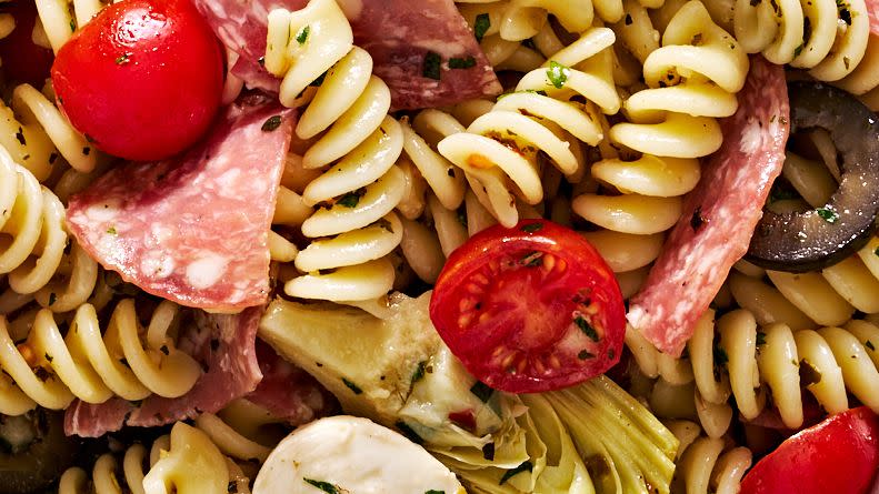 italian inspired pasta salad with cherry tomatoes, mozzarella, black olives, artichokes, and salami