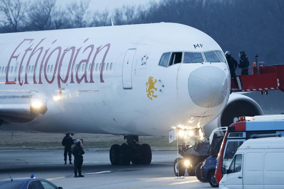 Police stand around the aircraft after passengers were evacuated from a hijacked Ethiopian Airlines Plane on the airport in Geneva, Switzerland, Monday, Feb. 17, 2014. A hijacked aircraft traveling from Addis Abeda, Ethiopia, to Rome, Italy, has landed at Geneva's international airport early Monday morning. Swiss authorities have arrested the hijacker. (AP Photo/Keystone, Salvatore Di Nolfi)