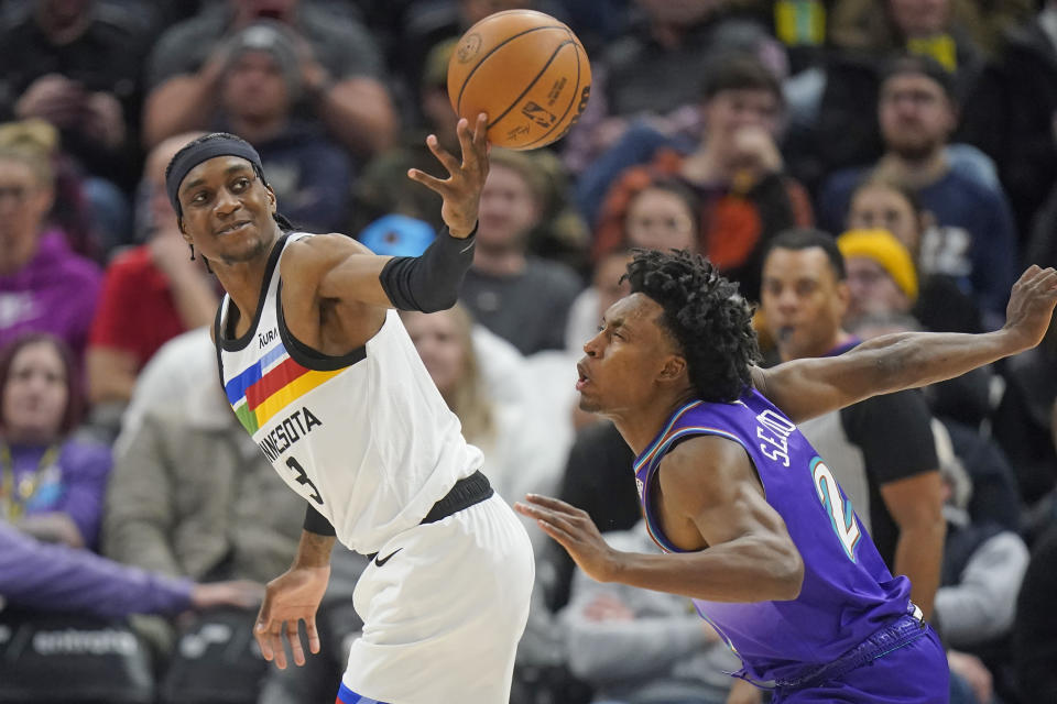 Minnesota Timberwolves forward Jaden McDaniels (3) reaches for a loose ball as Utah Jazz guard Collin Sexton (2) looks on during the second half of an NBA basketball game Wednesday, Feb. 8, 2023, in Salt Lake City. (AP Photo/Rick Bowmer)