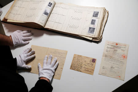 An album containing photographs and signatures of Jews from the Jewish community of Kavala in Greece, before most were killed in the Treblinka extermination camp, as well as other original documents are seen in the archive of the Yad Vashem World Holocaust Remembrance Center in Jerusalem, ahead of the Israeli annual Holocaust Remembrance Day, April 9, 2018. Picture taken April 9, 2018. REUTERS/Ronen Zvulun