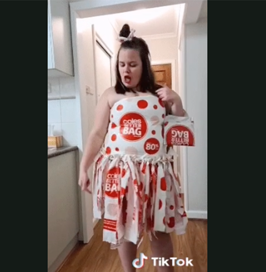 Woman poses in dress, handbag and hair bow made from Coles plastic bags