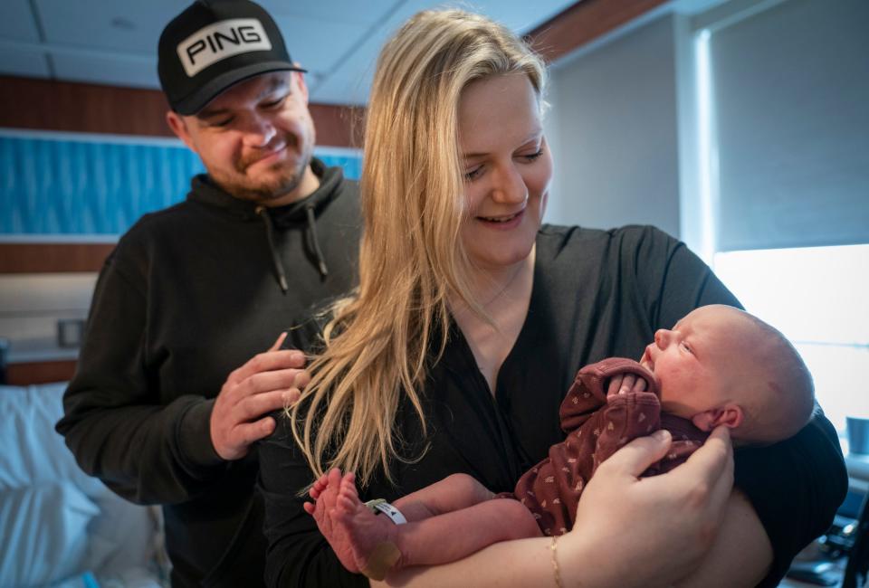 Happy to not have to wear masks during birthing, Chad Kelley, 32, left, looks on as his wife Ryanne Kelley, 29, holds their 1-day-old newborn Layne Kelley at Trinity Health Oakland Hospital in Pontiac on April 21, 2023. They have relaxed their masking mandates for staff and patients.