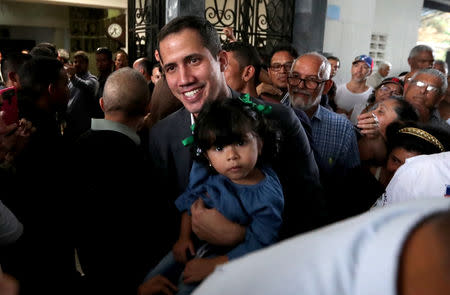 Venezuelan opposition leader Juan Guaido, who many nations have recognized as the country's rightful interim ruler, holds a child during a press conference after the meeting with public employees in Caracas, Venezuela March 5, 2019. REUTERS/Ivan Alvarado