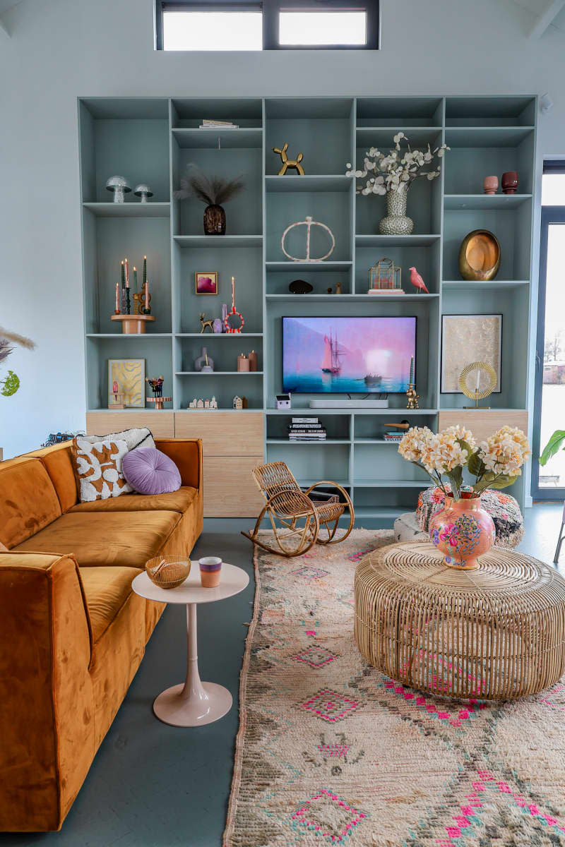 Large shelving unit anchors pastel living room on houseboat.