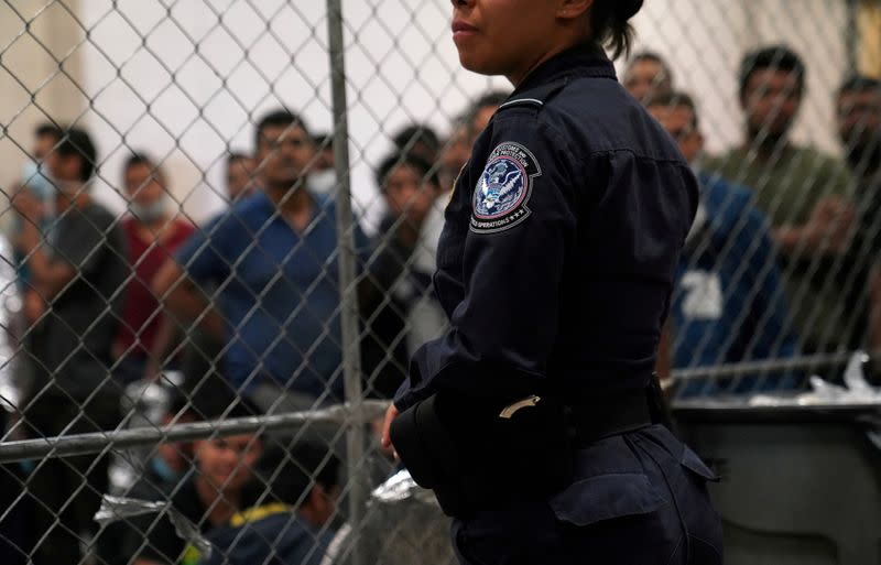 FILE PHOTO: A U.S. Customs and Border Protection agent monitors single-adult male detainees at Border Patrol station in McAllen, Texas