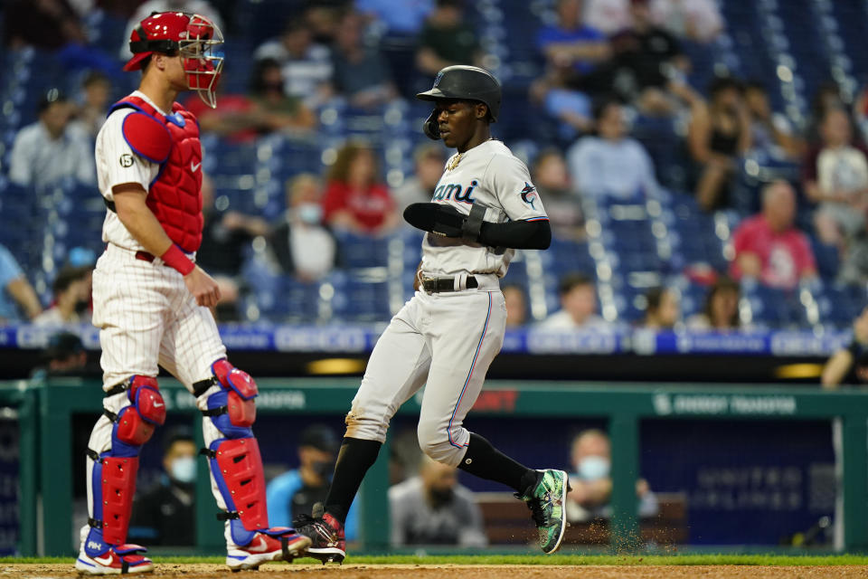 Miami Marlins' Jazz Chisholm Jr., right, scores past Philadelphia Phillies catcher Andrew Knapp on an RBI-sacrifice fly by Adam Duvall during the fourth inning of baseball game, Tuesday, May 18, 2021, in Philadelphia. (AP Photo/Matt Slocum)