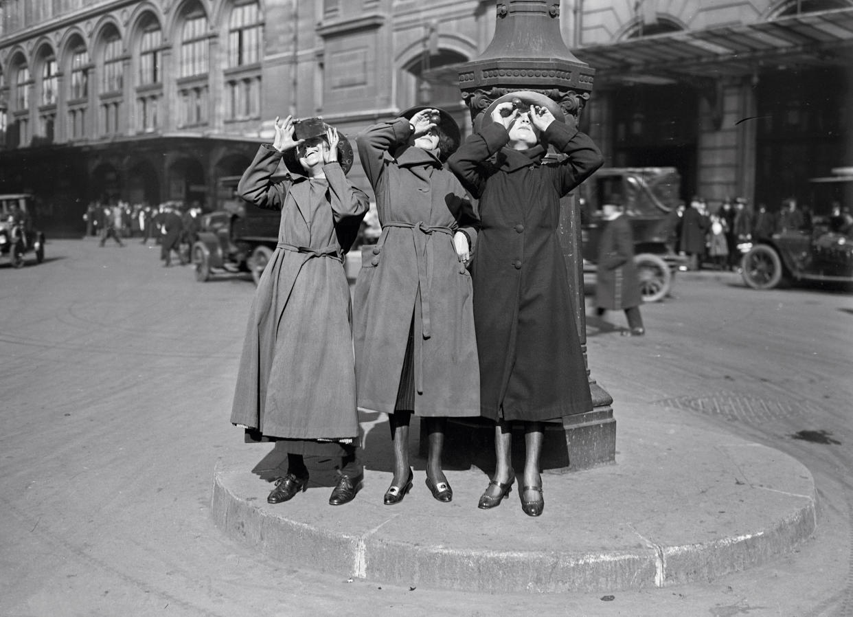 1921: Women observing a solar eclipse in Paris.