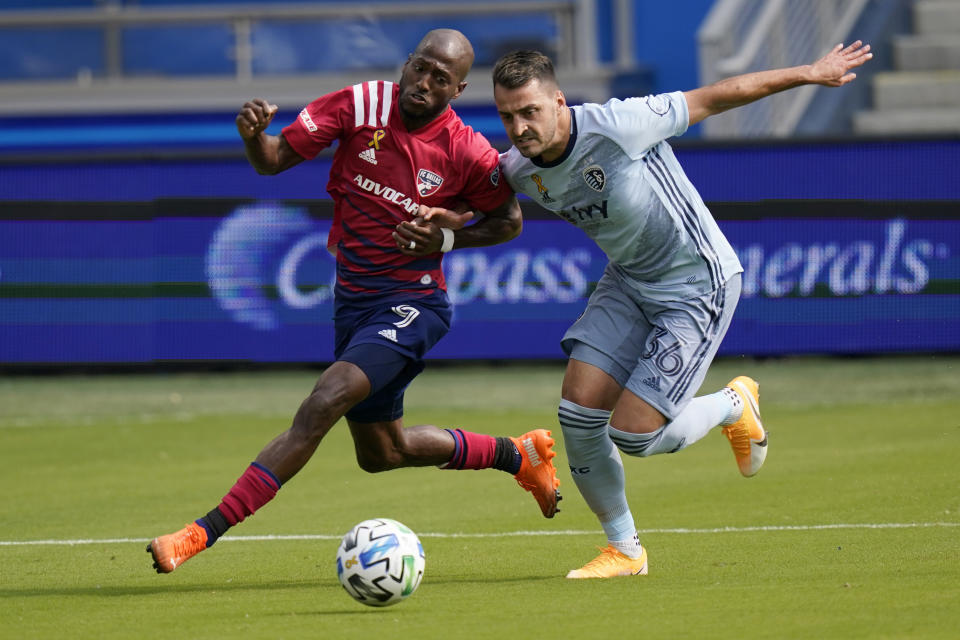 FC Dallas forward Fafa Picault (9) and Sporting Kansas City defender Luis Martins (36) chase the ball during the first half of an MLS soccer match in Kansas City, Kan., Saturday, Sept. 19, 2020. (AP Photo/Orlin Wagner)