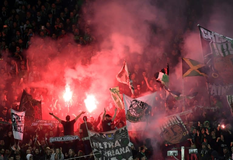 Saint-Etienne's supporters hold flares and wave flags during their UEFA Europa League football match against Manchester United on February 22, 2017