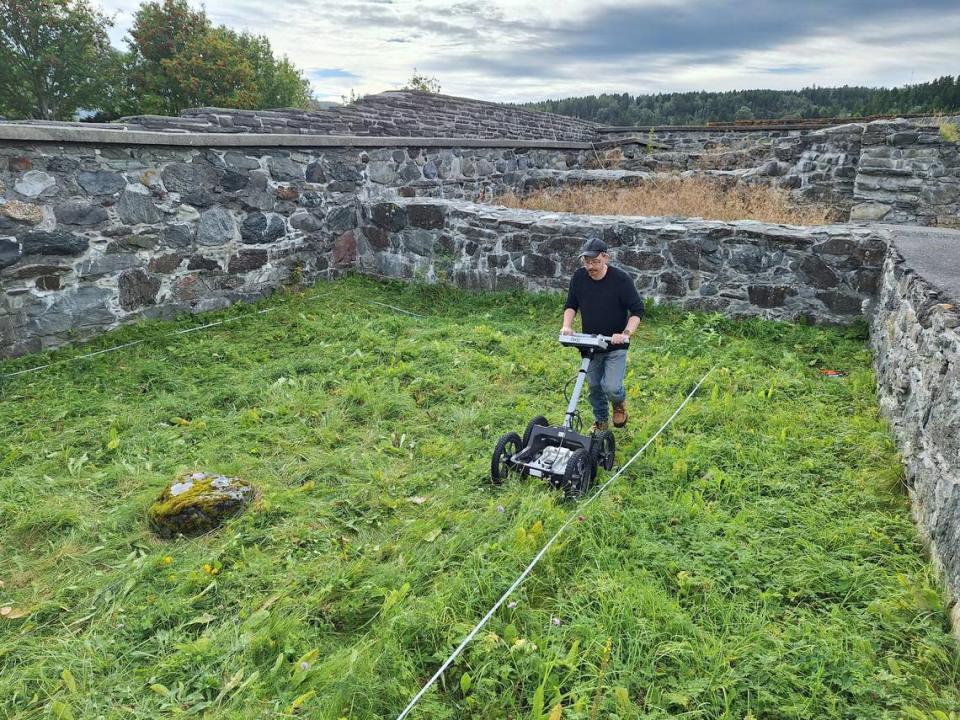 An archaeologists scans the courtyard with a ground penetrating radar.