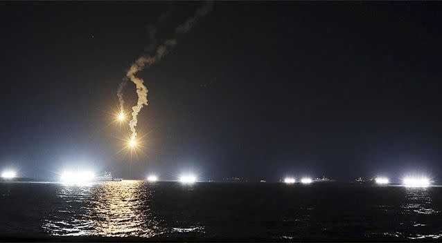 South Korean rescue team members search missing passengers of the sunken ferry Sewol in the water off the southern coast as flares illuminate the scene. Photo: AP.