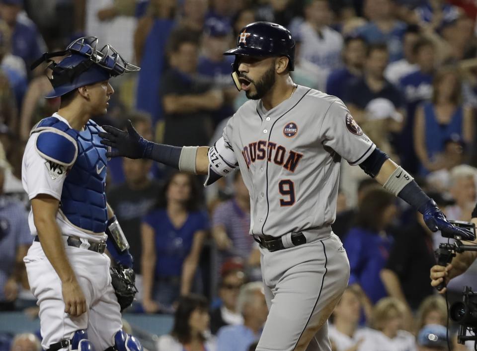 Houston Astros’ Marwin Gonzalez celebrates in front of Los Angeles Dodgers catcher Austin Barnes after hitting a home run during the ninth inning of Game 2. (AP)