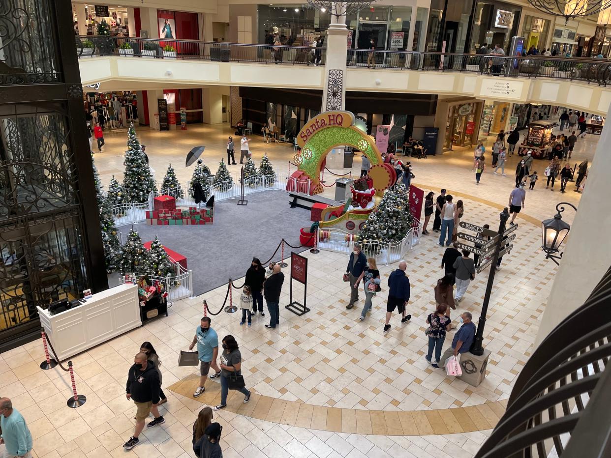 Black Friday shoppers stroll past holiday decorations at The Oaks mall in Thousand Oaks Friday afternoon.